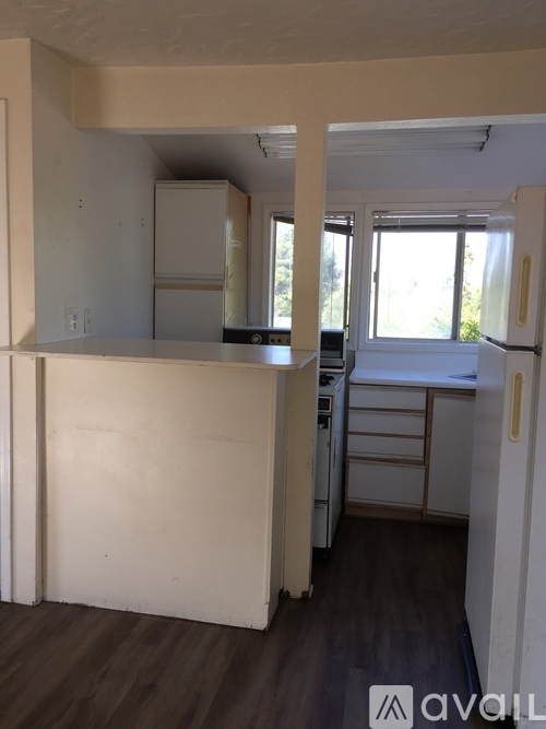 A kitchen with white cabinets and a window.