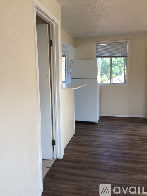 A room with a white door and a window with blinds.