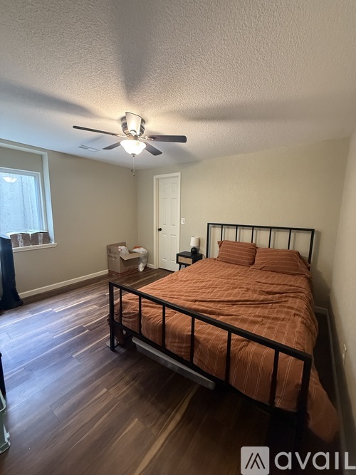 A bedroom with a bed, dresser, and window.