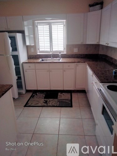 A kitchen with white cabinets and a brown countertop.