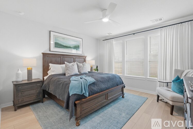 A bedroom with a bed, nightstand, and chair.