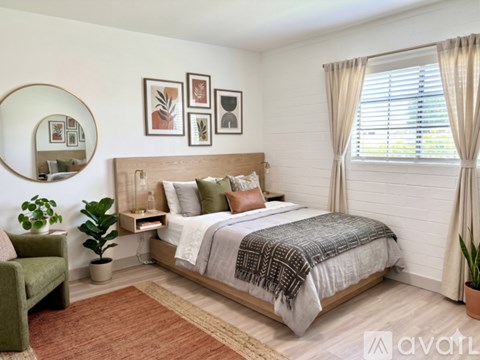 A bedroom with a large bed and a green chair.