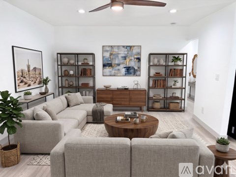 A living room with a grey sofa set, a wooden coffee table, and a painting on the wall.