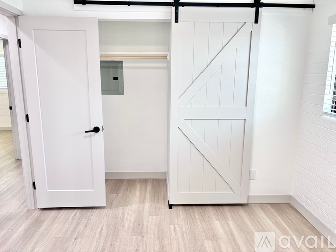 A white door is open to a small room with a window.