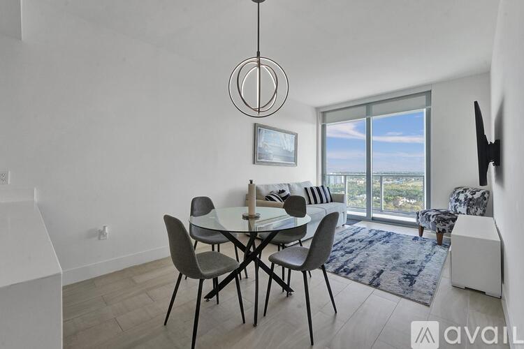 A modern dining room with a glass table and chairs.