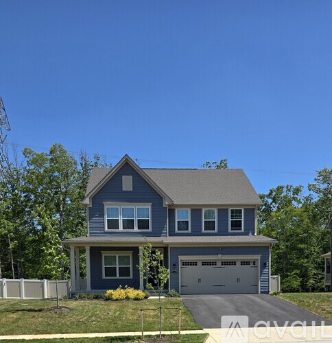 A two-story house with a garage and a driveway.