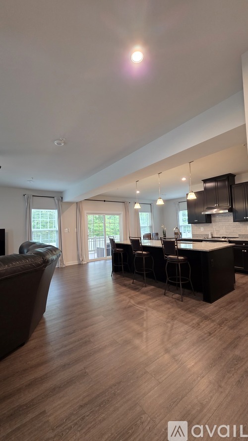 A modern kitchen with dark wood floors and a large island.