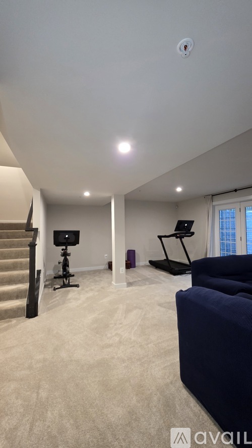 A living room with a staircase and a couch.