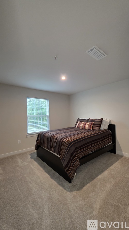 A bedroom with a bed and a window.
