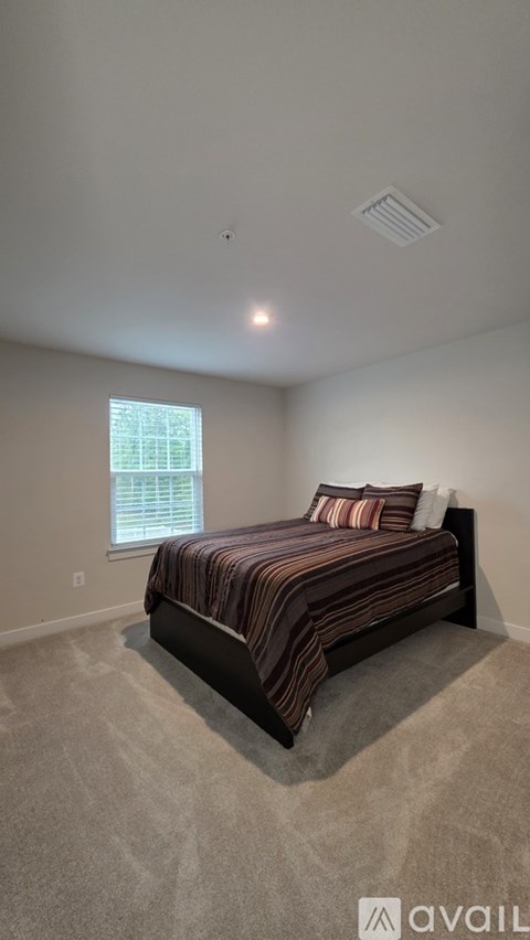 A bedroom with a bed and a window.
