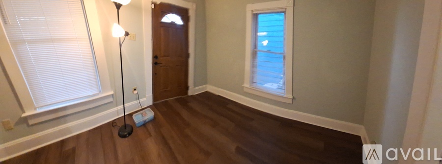 A room with a window and a door is available for rent.