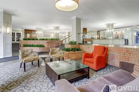 A living room with a glass table and orange armchair.