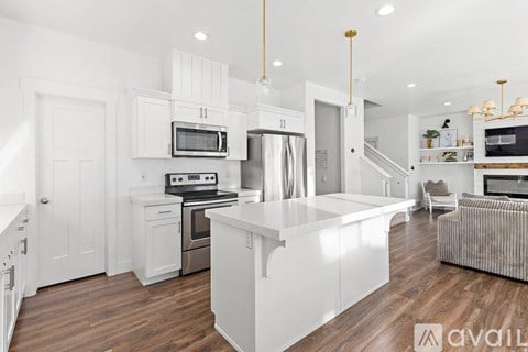 A modern kitchen with white cabinets and stainless steel appliances.