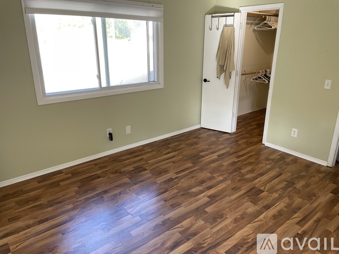 A room with a wooden floor and a white closet.