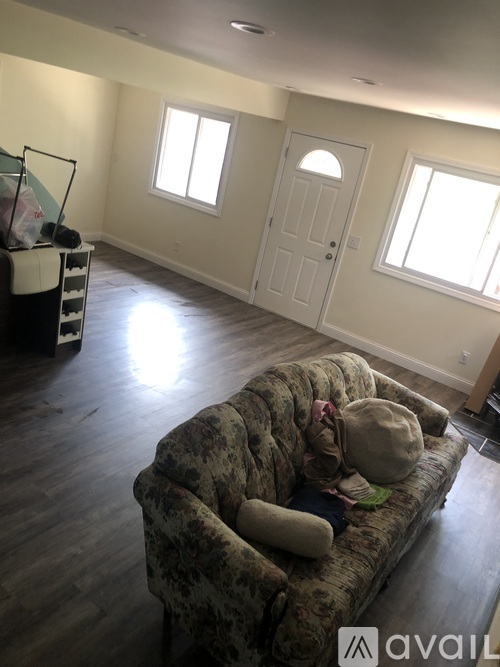 A living room with a floral sofa and a white door.