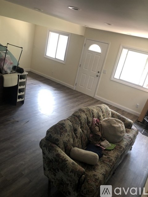 A living room with a floral sofa and a white door.