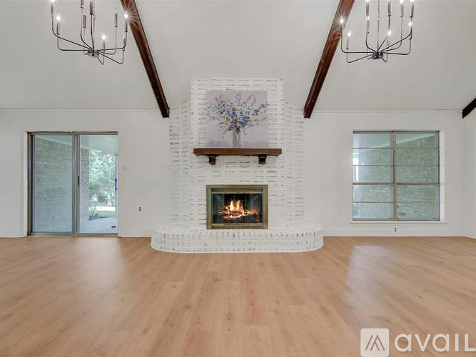 A large, modern living room with a fireplace and wooden floors.