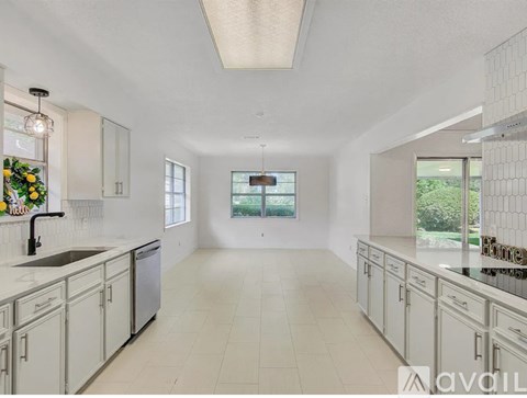 A spacious kitchen with white cabinets and a large island.