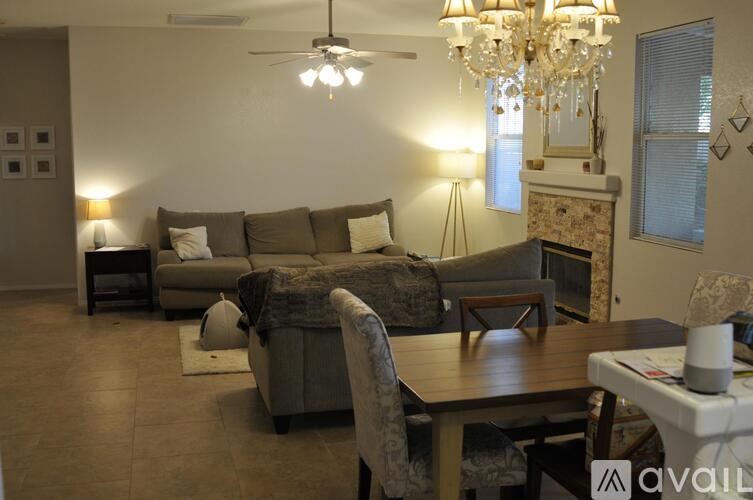 A living room with a couch, a chair, a coffee table, and a chandelier.