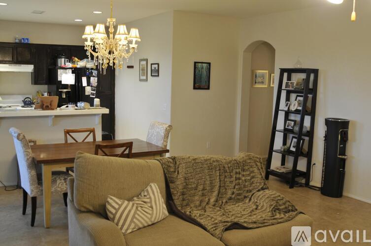 A living room with a couch, chairs, and a dining table.
