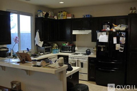 A kitchen with black cabinets and a white countertop.