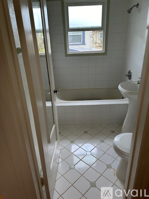 A bathroom with a white toilet, sink, and bathtub.