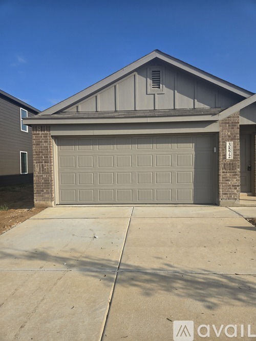 A house with a garage door and a driveway in front.