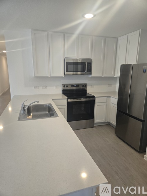 A kitchen with white cabinets and stainless steel appliances.