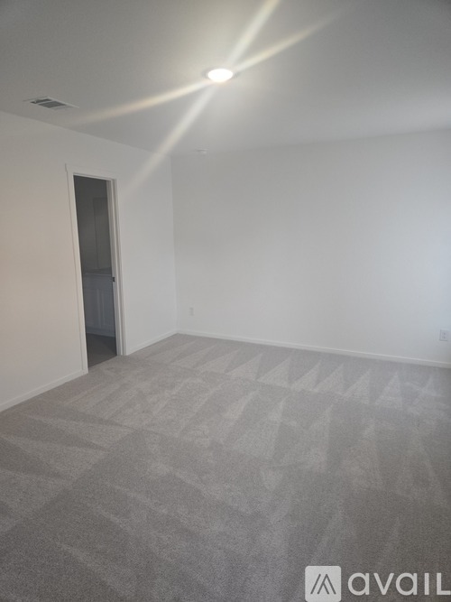 A room with a carpeted floor and a door.