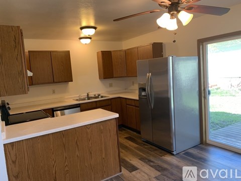A kitchen with wooden cabinets and a stainless steel refrigerator.