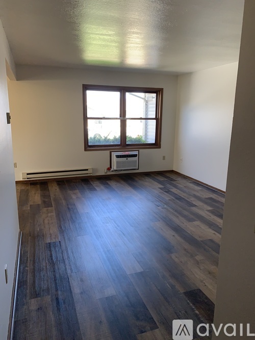 A room with wooden flooring and a window.