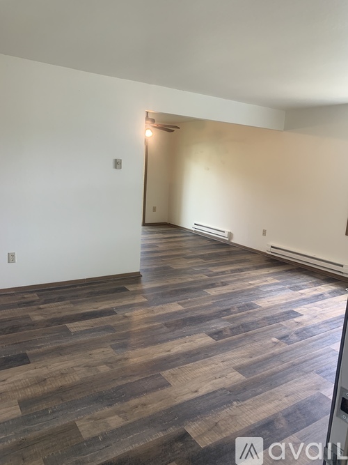 A room with wooden flooring and a white wall.