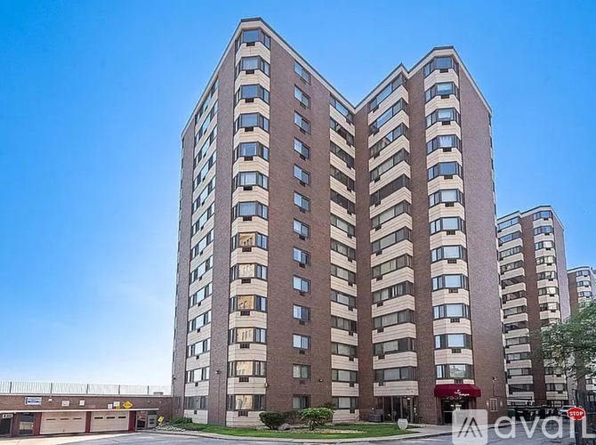 A tall brick apartment building with a clear blue sky in the background.