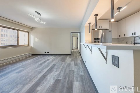 A modern kitchen with a long counter and a stainless steel range hood.