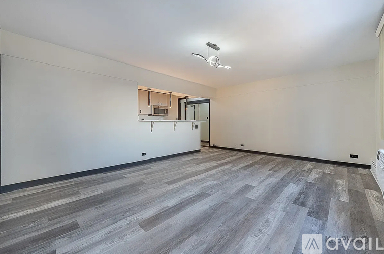 A spacious room with a grey floor and white walls.