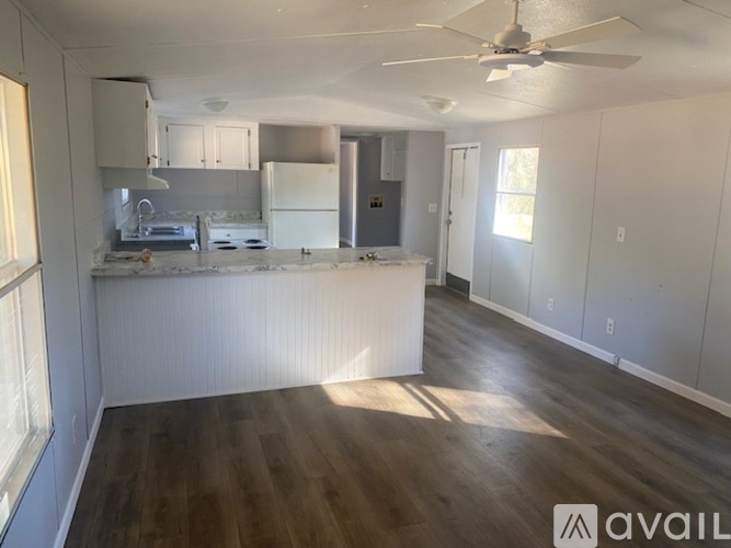 A room with a fan and wooden floors is available for rent.