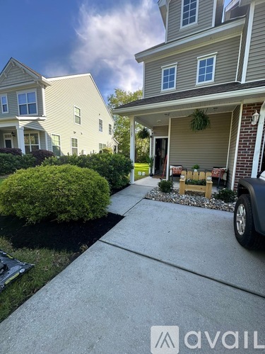 A house with a driveway and a car parked in front.