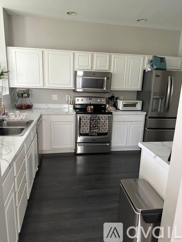 A kitchen with white cabinets and a stove top oven.