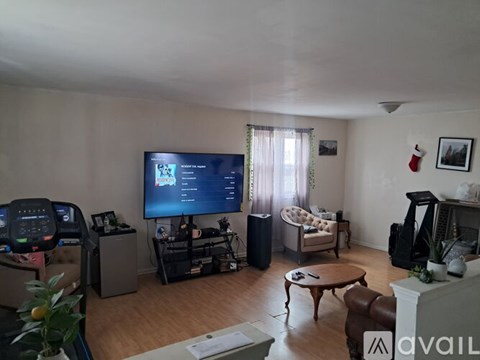 A living room with a television, a couch, a chair, a coffee table, and a fireplace.