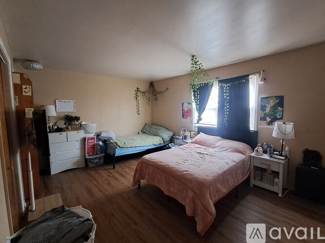 A bedroom with a bed, nightstand, and window.
