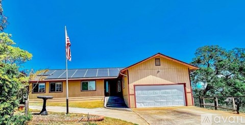 A house with a flag on the roof and a garage door.