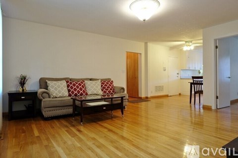 A living room with a grey couch and a wooden floor.