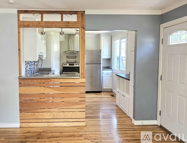 A kitchen with wooden floors and a white door.