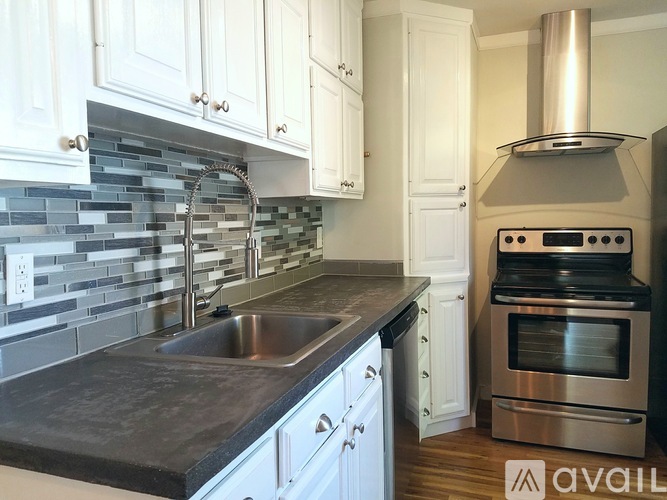A kitchen with white cabinets and a stainless steel oven.