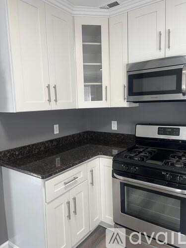 A kitchen with white cabinets and a black stove top.