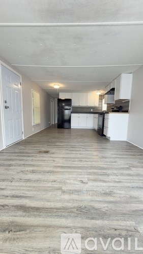 A kitchen area with a refrigerator, oven, and cabinets.