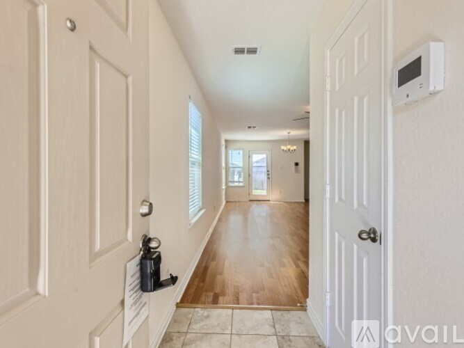 A hallway with white doors and a tiled floor.