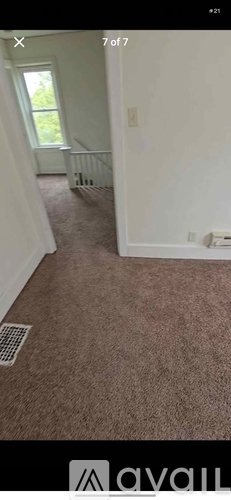 A room with a carpeted floor and a window.