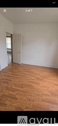 A room with wooden flooring and a white door.