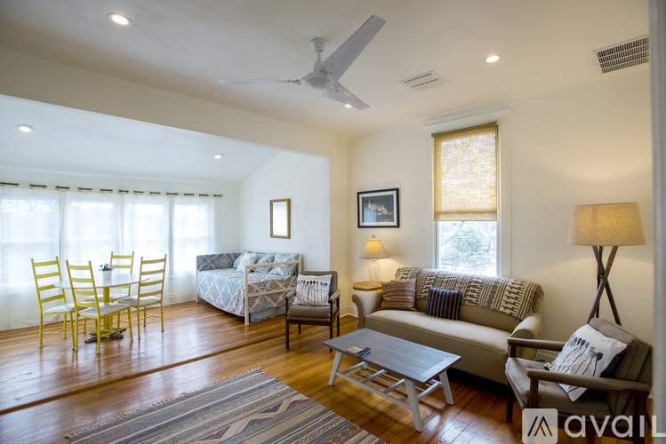 A living room with a couch, chairs, and a dining table.